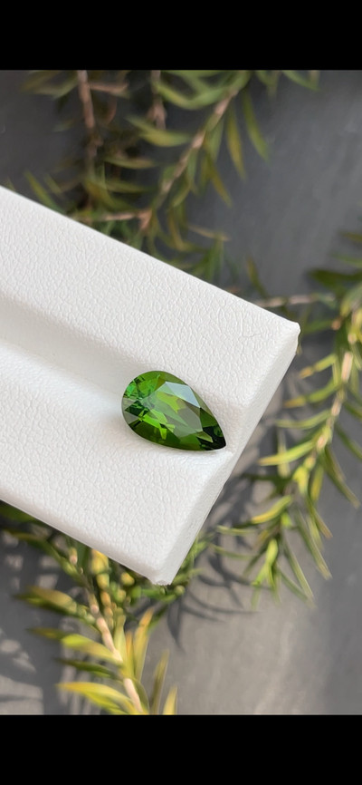 Pear cut green tourmaline, 12.7 by 7.68 mm, shown at actual size